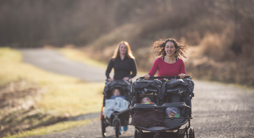 two women running with strollers
