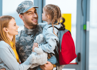 family greeting dad in military uniform at the airport